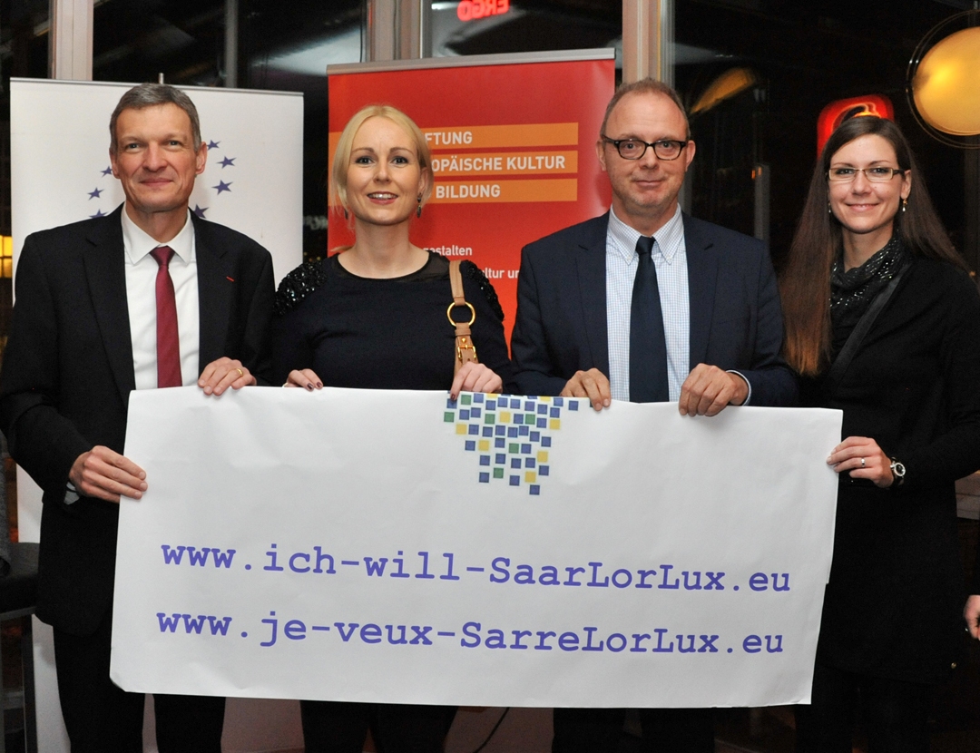 Europaminister Stephan Toscani, Melanie Binkert (Projektteam), Hanno Thewes (Landesvorsitzender der EU Saar) und Patricia Lugenbiehl (Projektteam) halten die Webadressen von Ich will SaarLorLux hoch